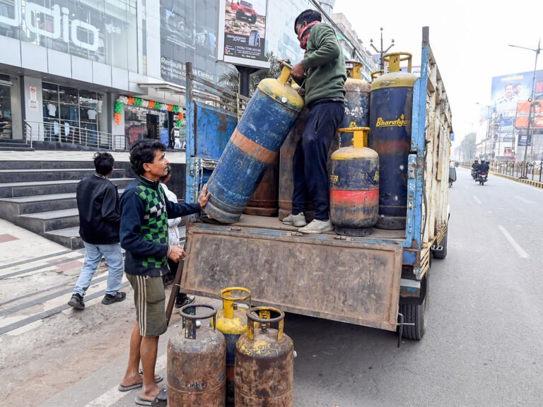 A worker carries a LPG cylinder