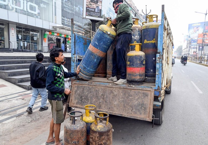 A worker carries a LPG cylinder
