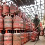 A worker moves an LPG cylinder