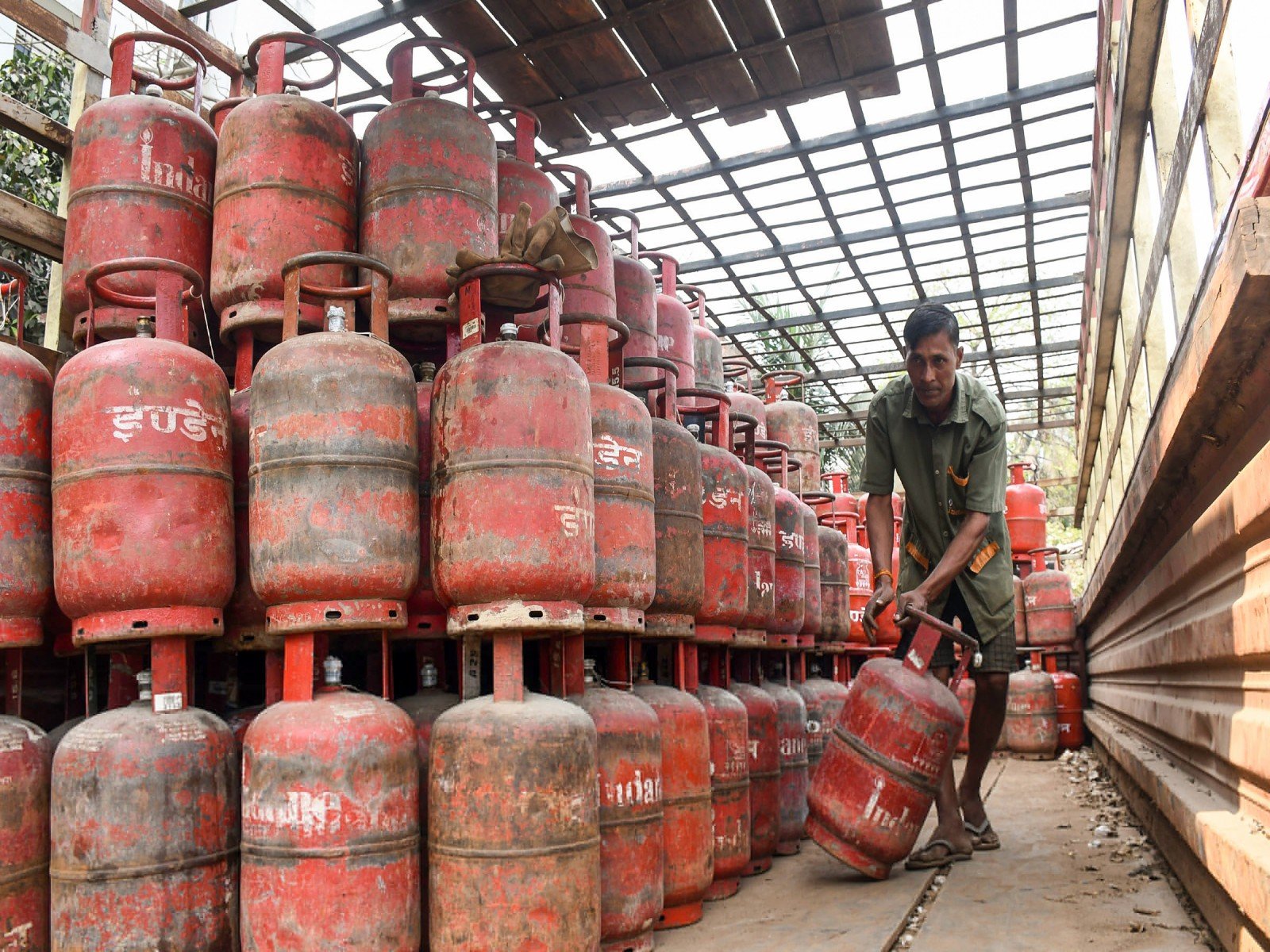 A worker moves an LPG cylinder